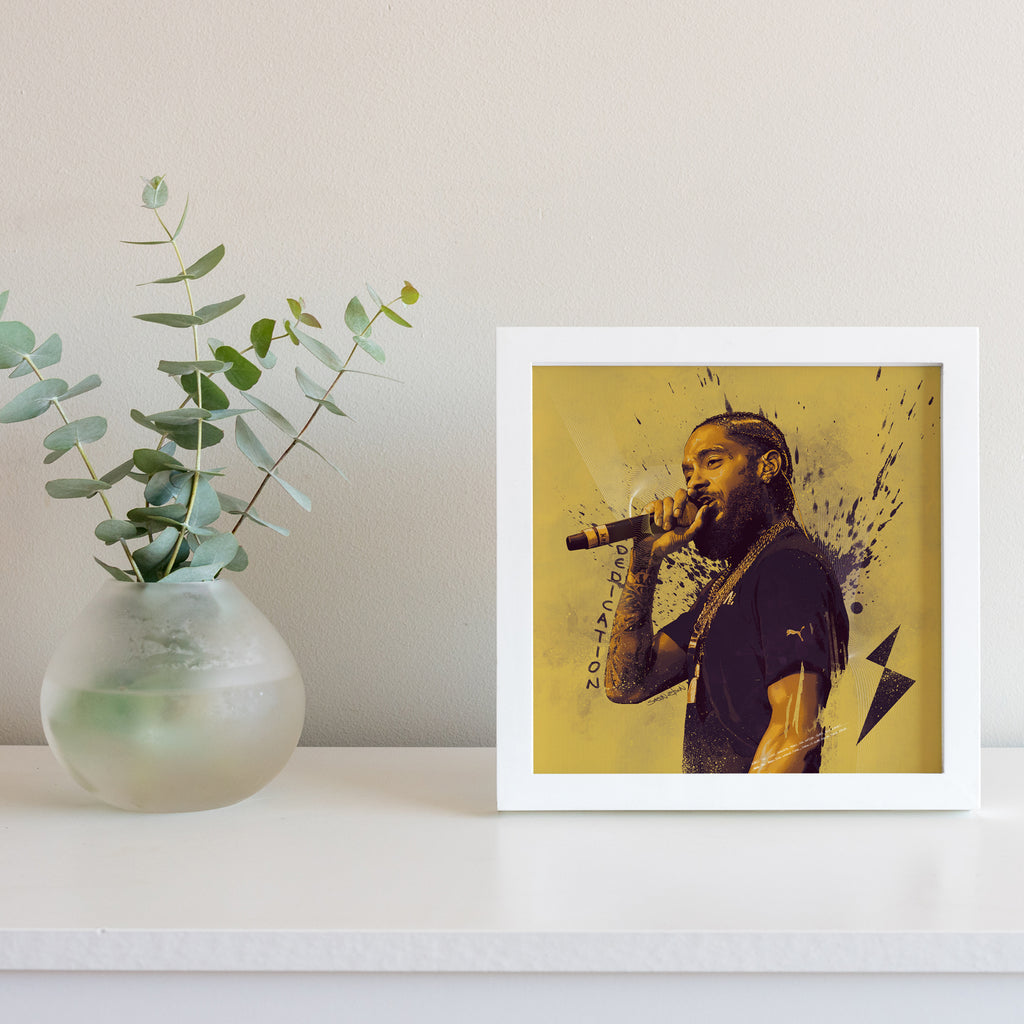 "Nipsey Hussle art print in white frame with plant — illustrated rap music poster for living room"